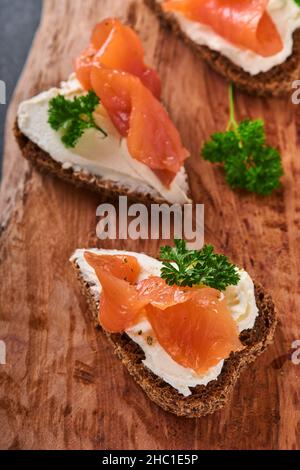 Mini sandwiches avec du saumon, du fromage caillé, du persil et du pain de seigle sous forme de coeurs.Saint-Valentin cuisine créative maison.J'adore le design du petit déjeuner.Séle Banque D'Images