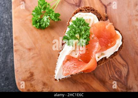 Mini sandwiches avec du saumon, du fromage caillé, du persil et du pain de seigle sous forme de coeurs.Saint-Valentin cuisine créative maison.J'adore le design du petit déjeuner.Séle Banque D'Images