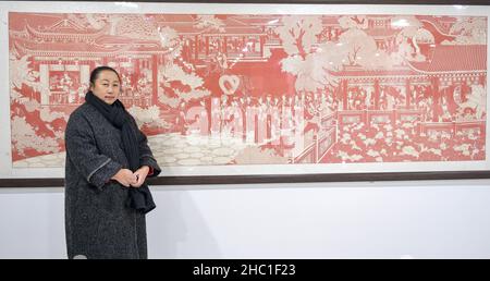 (211222) -- CHANGCHUN, 22 décembre 2021 (Xinhua) -- Li Baofeng pose pour une photo avec son œuvre d'art à Changchun, dans la province de Jilin, dans le nord-est de la Chine, 17 décembre 2021.Li Baofeng, 56 ans, est un artiste de découpe de papier à Jilin.En combinant la technique traditionnelle de coupe de papier avec des caractéristiques de diverses formes de peinture comme la peinture chinoise, la peinture à l'huile et la gravure, Li crée son propre style d'art.Ses œuvres sont riches en couleurs et fortes en trois dimensions.La plupart de ses créations se concentrent sur la littérature classique chinoise, les coutumes populaires et les paysages.L'une de ses œuvres « Rouge chinois » dépeint une série de sto Banque D'Images