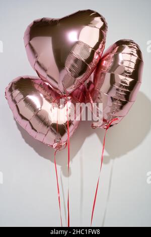 Un ensemble de jetons d'amour en forme de cœur.Un cadeau pour montrer l'amour pour un autre.Ballons d'hélium roses. Banque D'Images