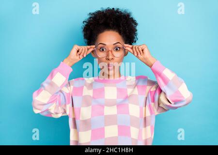 Portrait d'une jolie petite fille amusante émerveillement fille à cheveux ondulés touchant les lèvres put isolées sur fond bleu vif Banque D'Images