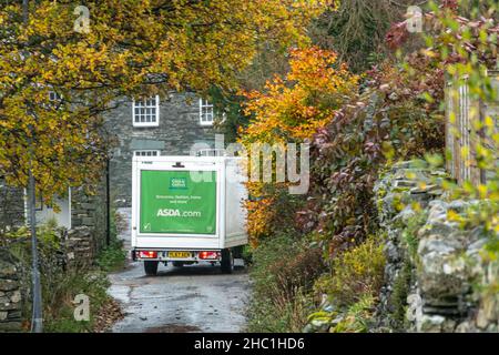 La camionnette Asda traverse une étroite ruelle de campagne dans le village de Rosthwaite, dans le Lake District, Cumbria, Royaume-Uni, pendant l'automne Banque D'Images