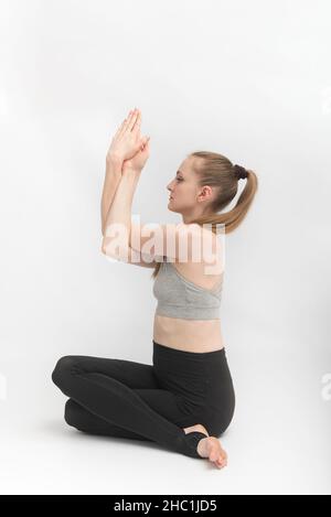 Gomukhasana.Posture de la vache.Jeune femme mince et flexible pratique le yoga.Hatha yoga.Vue latérale. Banque D'Images