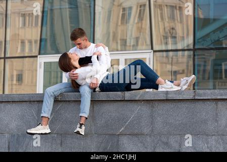 Fille a mis sa tête sur les genoux de son petit ami.Guy hople sa petite amie.Jeune couple dans la ville.Date romantique. Banque D'Images