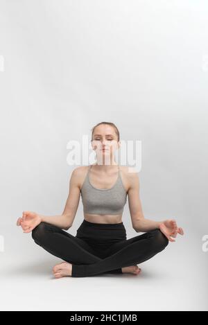 Sukhasana.Pose facile.Jeune femme mince fait du yoga et médite.La fille pratique pranayama.Photo de haute qualité Banque D'Images