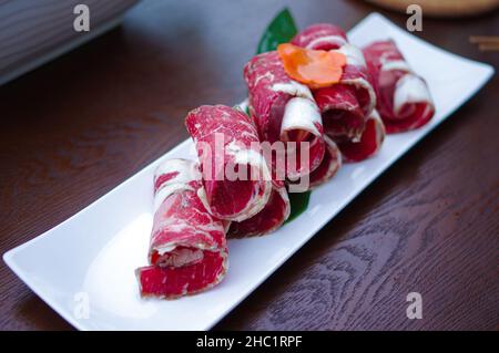 Tranches de rouleaux de bœuf cru pour le hot pot sur la plaque blanche Banque D'Images