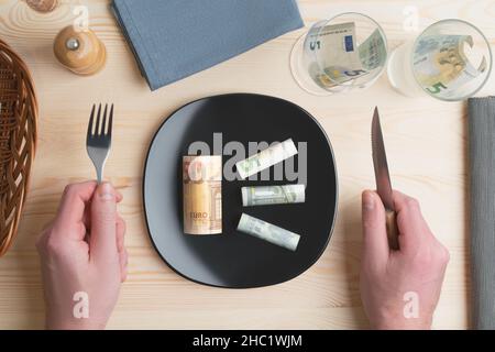 Studio conceptuel de la table de dîner avec des billets de banque euro sur l'assiette au lieu de la nourriture.Concept de la hausse des prix alimentaires, de l'inflation, de la crise économique Banque D'Images