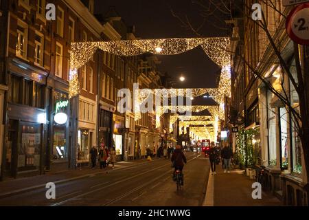 Amsterdam, 18 décembre.14th janvier 2022.Les gens marchent dans une rue avec des décorations de Noël à Amsterdam, aux pays-Bas, le 18 décembre 2021.Samedi, le gouvernement néerlandais a annoncé un verrouillage plus strict par crainte de la montée de la variante Omicron du COVID-19 dans le pays.Le nouveau verrouillage entrera en vigueur à partir de 5 h le dimanche matin, heure locale, et demeurera en vigueur jusqu'au 14 janvier 2022.Credit: Sylvia Lederer/Xinhua/Alamy Live News Banque D'Images