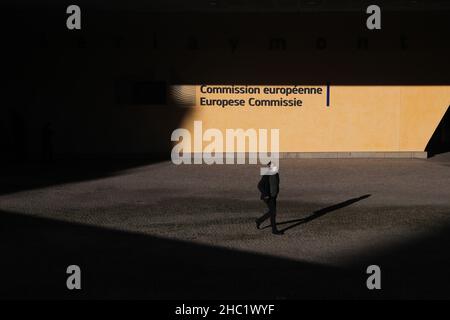 Bruxelles, Belgique.21st décembre 2021.Un homme passe devant le bâtiment de la Commission européenne à Bruxelles, Belgique, le 21 décembre 2021.Selon le microbiologiste Emmanuel Andre, la Belgique est au milieu d'une nouvelle vague de pandémie de COVID-19 due à la variante Omicron, qui représentait 20 pour cent de tous les résultats positifs des tests effectués dans tout le pays lundi matin.Credit: Zheng Huansong/Xinhua/Alay Live News Banque D'Images