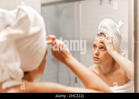 Femme adulte appliquant de la crème hydratante pour le soin de la peau sur le front. Banque D'Images