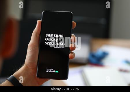 Homme main tenant nouveau téléphone mobile samsung galaxie S22 ultra 5g gros plan Banque D'Images