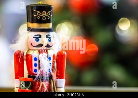 Statue de casse-noisette soldat debout devant l'arbre de Noël avec lumières. Banque D'Images