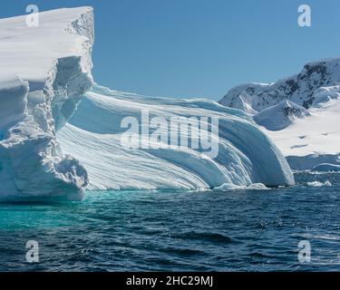 Un iceberg aux tons turquoise montrant des courbes et des textures flottant dans la baie de Wilhelmina, en Antarctique Banque D'Images