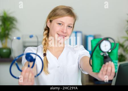 femme médecin tenant et montrant un sphygmomanomètre Banque D'Images