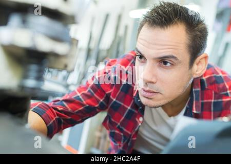 Homme dans un entrepôt est de vérifier les niveaux de stock de marchandises Banque D'Images