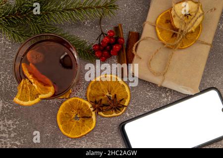 Vin chaud sur une table en bois dans un verre.Et un téléphone portable.Vue de dessus. Banque D'Images