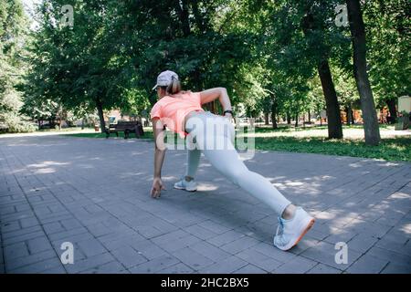 belle jeune femme sportive au parc dans les vêtements de sport échauffement s'étirant se préparer pour commencer Banque D'Images