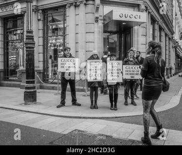 Les activistes tiennent des pancartes exigeant que Gucci cesse d'utiliser des peaux exotiques pour leurs ceintures et sacs à main. Banque D'Images