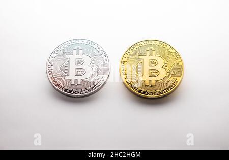 Deux pièces d'or et d'argent crypto Bitcoin photographiées sur fond blanc, comme un produit de tournage Banque D'Images