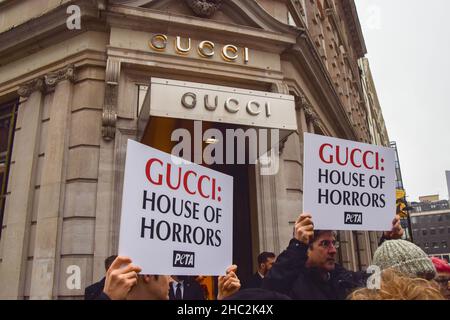 Londres, Royaume-Uni.23rd décembre 2021.Les activistes tiennent des pancartes de la « Gucci: House of Horrors » pendant la manifestation.les militants du PETA (People for the Ethical Treatment of Animals) se sont rassemblés devant le magasin Gucci de Bond Street et ont organisé une « passerelle » avec des sacs à main éclatés de faux sang pour protester contre l'utilisation de peaux de lézard dans les produits de Gucci.L'enquête de PETA a montré que les fournisseurs de peau de lézard tombent bien en dessous des normes de bien-être des animaux et causent d'énormes souffrances pour les animaux.(Photo de Vuk Valcic/SOPA Images/Sipa USA) crédit: SIPA USA/Alay Live News Banque D'Images