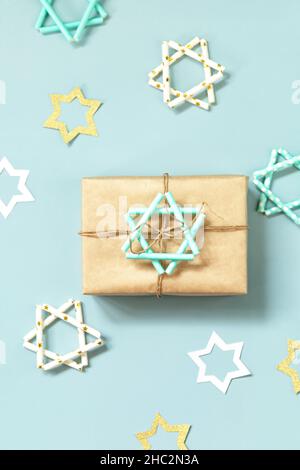 Vacances juives Hanukkah.Un cadeau et un symbole de la star Hanoukkah de David sur fond bleu.Plan d'étapage avec vue de dessus. Banque D'Images