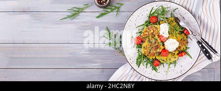 Les courgettes crêpes de maïs et la crème servi la roquette, salade de tomates. Bannière. Vue d'en haut Banque D'Images