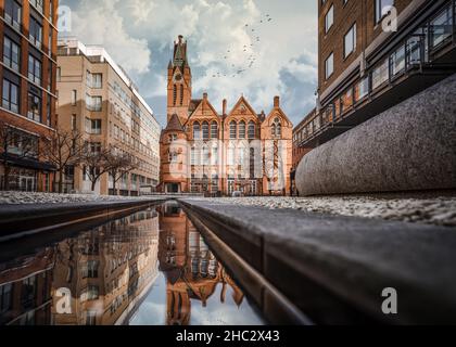 Le bâtiment de l'église en brique rouge de Brindley place se reflète dans l'eau.Les bâtiments historiques des West Midlands se réaménagé dans la rue de réflexion du centre-ville historique Banque D'Images