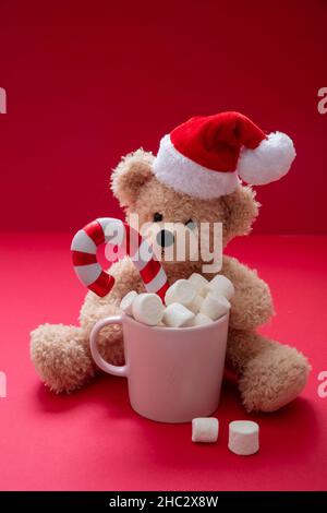 Boisson chaude de Noël et de fête du Père Noël, tasse au chocolat avec guimauves et canne à sucre sur fond rouge, Banque D'Images