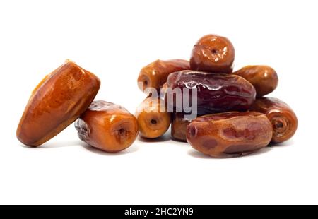 Les dates sont isolées.Les dates se déversent d'une tasse en forme de coeur sur un fond blanc gros plan.Fruits secs Banque D'Images