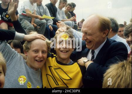 Le chef du Parti travailliste Neil Kinnock avec de jeunes partisans à Newcastle sous Lyme 1986 Banque D'Images