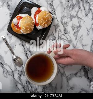 Helsinki / Finlande - 12 DÉCEMBRE 2021 : photo aérienne d'une plaque avec des petits pains traditionnels et une tasse de thé sur un comptoir en granit Banque D'Images