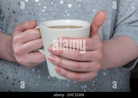Helsinki / Finlande - 12 DÉCEMBRE 2021 : une femme caucasienne tenant une tasse de thé Banque D'Images