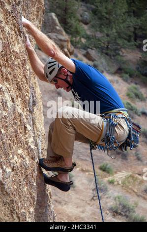 Grimpeur de roche mâle unique au parc national de Smith Rock.Oregon Banque D'Images