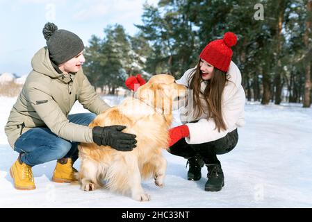 Couple aimant jouant avec le chien en forêt d'hiver .Bonne famille Banque D'Images