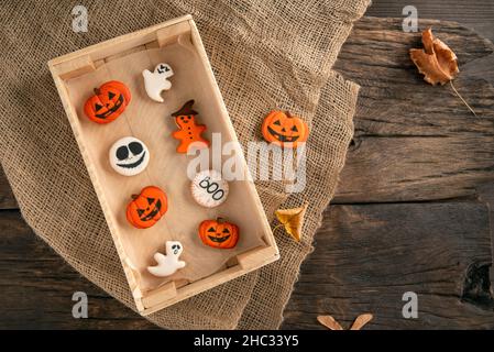 Un mélange de biscuits au gingembre blanc et orange pour Halloween est emballé dans une boîte en bois et sur une table en bois.Gâteries pour les vacances.Photo de haute qualité Banque D'Images