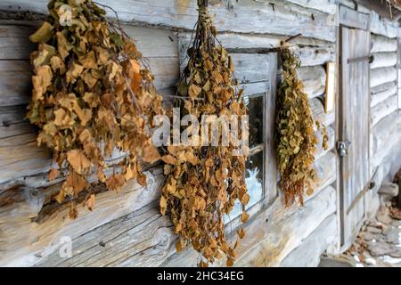 Bains besoms accrochés sur le mur de la maison de bains de Vidzeme avec maison de logement sous la neige.Son lieu d'origine est Sēli, Jaunrūnas Lettonie, et il a été construit Banque D'Images