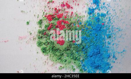 Vue de dessus des encres colorées sèches tombant dans une substance liquide blanche.Magnifique fond irisé de poudre verte, bleue et rose en fluide blanc Banque D'Images