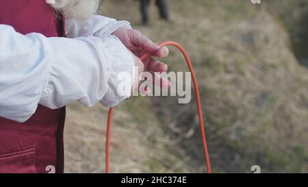 Ancienne technique de pêche, pêcheur en costume traditionnel obtenant un filet de pêche.Homme dans de vieux vêtements de rococo de manière tirant un filet de pêche, standi Banque D'Images