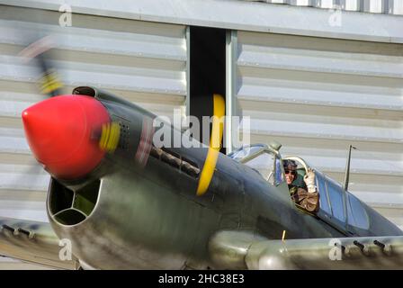 Propriétaire pilote Peter Teichman Curtiss P-40 Kittyhawk G-KITT extérieur Hangar 11.Portant un programme temporaire lavable à l'eau, après avoir filmé le film Red Tails Banque D'Images