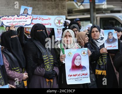 Gaza, Palestine.22nd décembre 2021.Les femmes palestiniennes tiennent des portraits de prisonniers, lors d'une manifestation de solidarité avec les prisonniers palestiniens à l'intérieur des prisons israéliennes, devant le bâtiment de la Croix-Rouge à Gaza.(Photo par © Yousef Masoud/SOPA Images/Sipa USA) crédit: SIPA USA/Alay Live News Banque D'Images