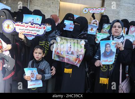 Gaza, Palestine.22nd décembre 2021.Les femmes palestiniennes tiennent des portraits de prisonniers, lors d'une manifestation de solidarité avec les prisonniers palestiniens à l'intérieur des prisons israéliennes, devant le bâtiment de la Croix-Rouge à Gaza.Crédit : SOPA Images Limited/Alamy Live News Banque D'Images