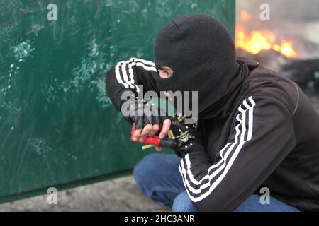 Naplouse, Palestine.23rd décembre 2021.Un palestinien masqué est couvert, pendant la manifestation. Les Palestiniens ont protesté pour la reconstruction de la colonie juive d'Homesh, qui a été évacuée en 2007.Des colons israéliens ont détruit des villages, des maisons et des voitures palestiniens pendant la manifestation dans le village de Burqa.Crédit : SOPA Images Limited/Alamy Live News Banque D'Images