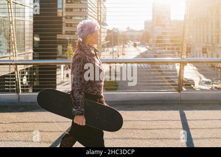 Italie, femme à la mode avec la ville de skateboard Banque D'Images
