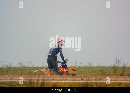 Un cycliste à moteur (motard) qui conduit sa moto tout-terrain le long d'une piste en pierre boueuse sur Salisbury Plain, Wiltshire Banque D'Images