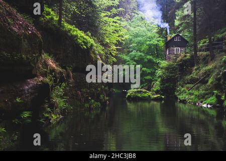 Magnifique refuge parmi les arbres se reflétant dans la rivière Kamenice, parc national de Bohême Suisse Banque D'Images