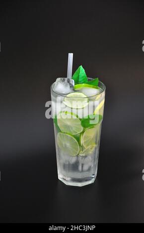 Mojito, un cocktail alcoolisé dans un grand verre avec de la glace, des morceaux de lime et des feuilles de menthe.Disposition verticale. Banque D'Images