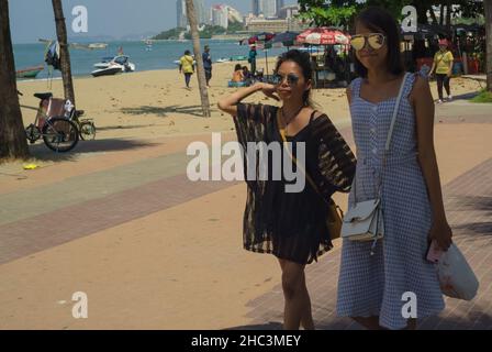 Pattaya, THAÏLANDE - 18 OCTOBRE 2019:La plage Deux jeunes femmes thaïlandaises marchaient le long de la plage par une journée lumineuse et ensoleillée. Banque D'Images