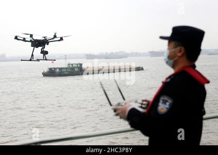 NANJING, CHINE - le 24 DÉCEMBRE 2021 - Un policier qui exploite un drone de police à un poste de contrôle frontalier d'entrée se prépare à effectuer un appel aérien Banque D'Images