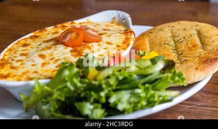 Gros plan de cannelloni avec pain plat à l'ail et salade Banque D'Images