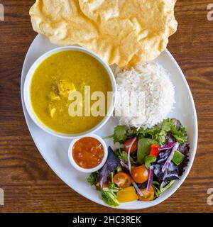 Vue de dessus de la cuisine traditionnelle indienne. La soupe épicée, la salade, le riz et la sauce rouge avec du pain Banque D'Images